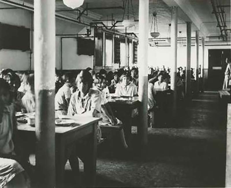 Group of students at tables eating at Edmonton Poundmaker school
