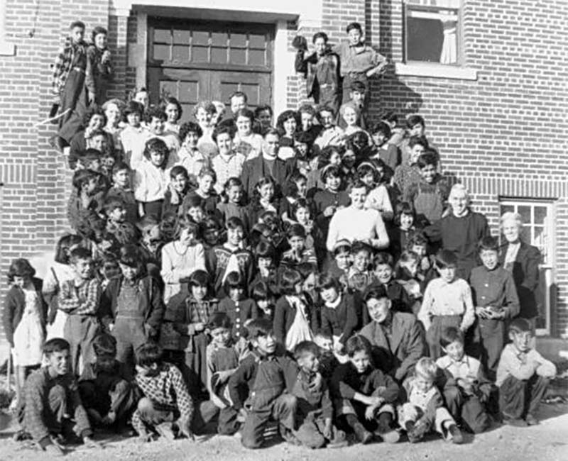 Group of students and teachers outside building at Gordon's school