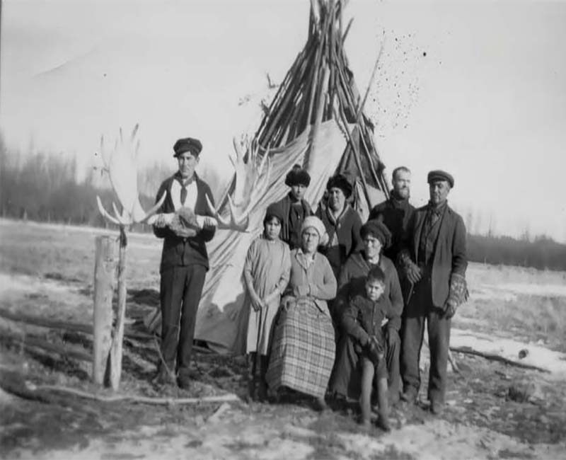 Group of people outside at Joussard St. Brunos school posing in front of teepee