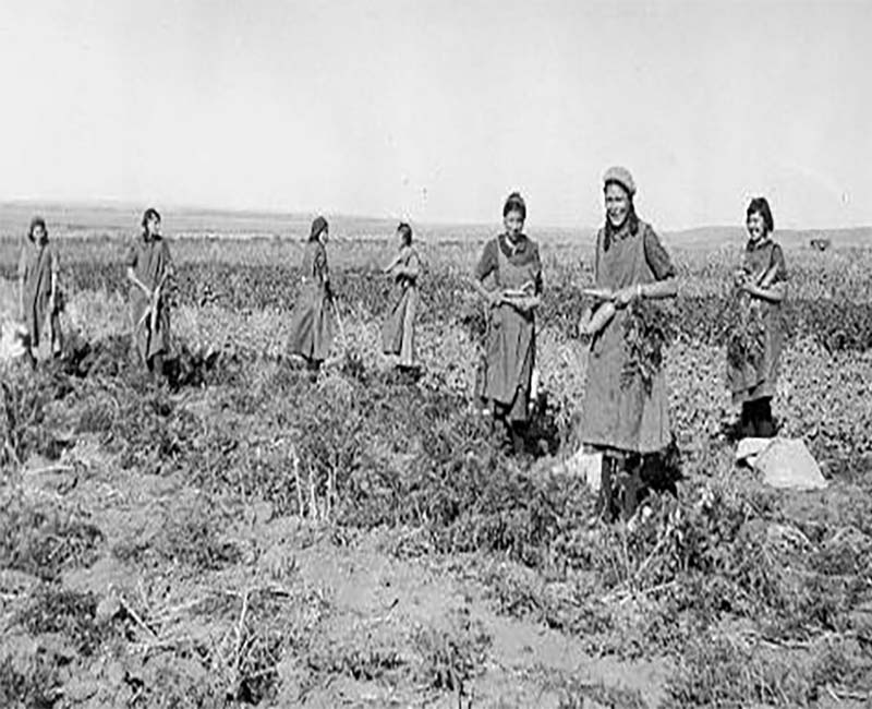 Group of people in field at Old Sun Blackfoot school 