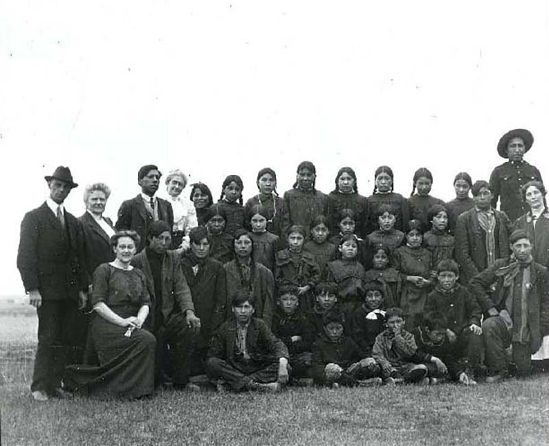 Group of students and teachers outside at Old Sun Blackfoot school 