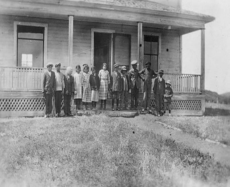 Group of people outside building at Sacreee St. Barnabas school