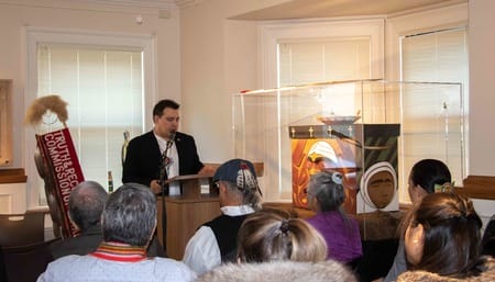 person speaking at a podium to a group of people