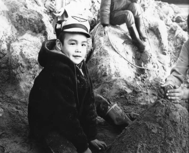 Student playing outside in sand