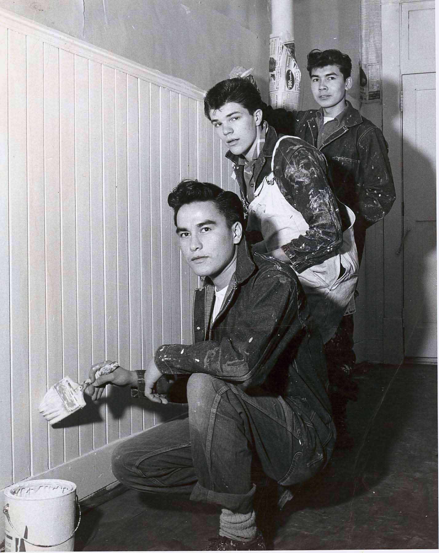 Three people painting a wall