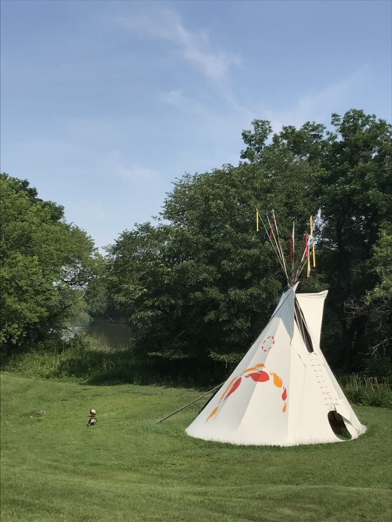 A teepee in a field.