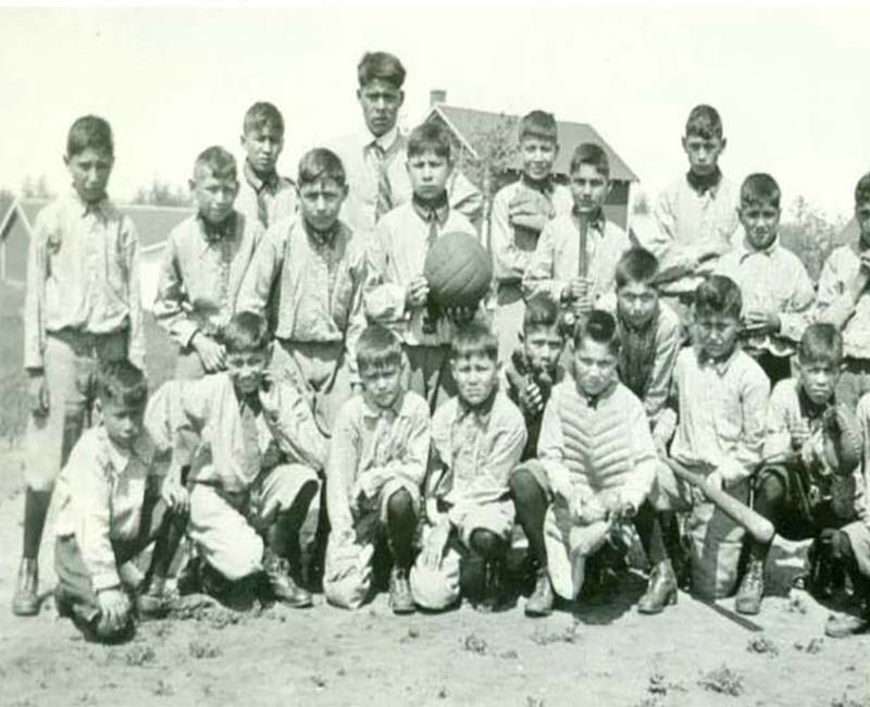 Group of students playing baseball outside St. Phillips school
