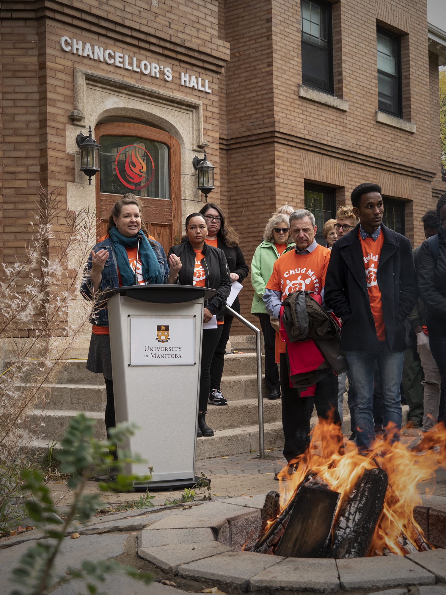 Trish speaking at podium outside the NCTR on Orange Shirt Day