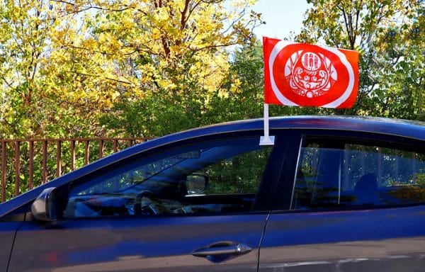 Product Image of a car flag version of the Survivors’ Flag attached to a blue car