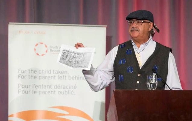 Eugene Arcand with the photo of his classmates at St. Michael’s Residential School.
