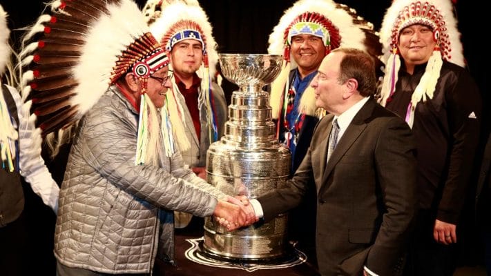 Fred Sasakamoose meets NHL commissioner Gary Bettman with the Stanley Cup behind them.