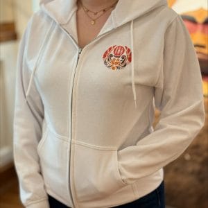 Product image of the front of a white full zip sweatshirt with the survivors flag design on the front and nctr name in French and English across the back